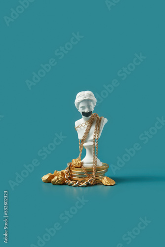 Statue with taped mouth with gold and coins. photo