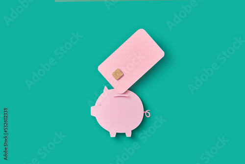 Papercraft piggy bank and pink credit card. photo