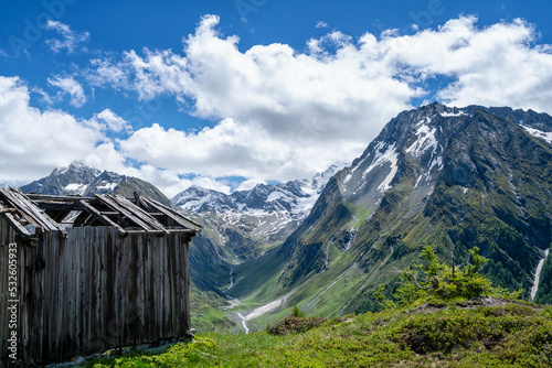 Fotografiet The Old Hut In A Scenic View Of Mountains Against Sky And Clouds