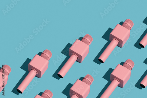 Pink microphones on blue background. Repetition pattern.