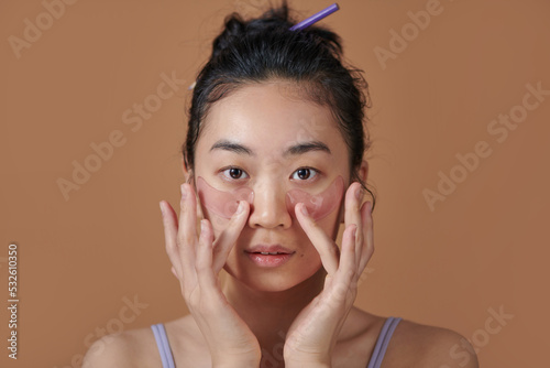 Asian girl with cosmetic collagen pink patches under eyes, cares photo