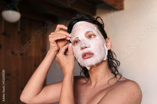 Woman using a facial mask during her skincare routine photo