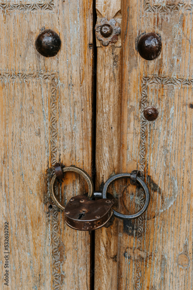 Old decorated wooden door with padlock Old decorated wooden door with padlock
