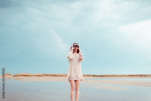 Portrait of woman using binoculars at wild beach
