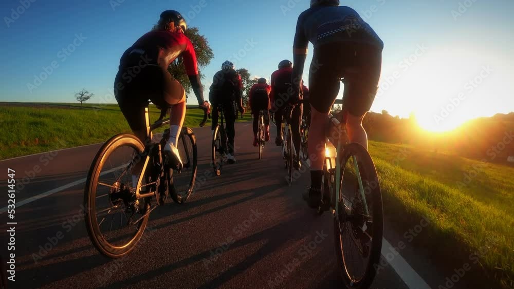 Cyclists riding bicycles in golden sunset lights
