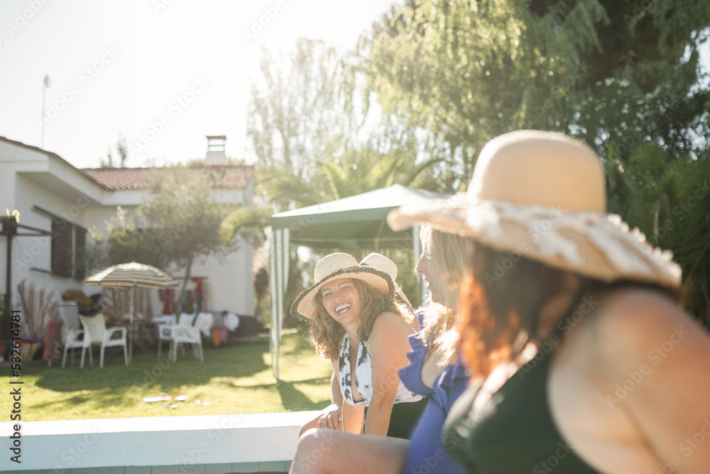 mature women sitting on the edge of a swimming pool in summer Stock ...