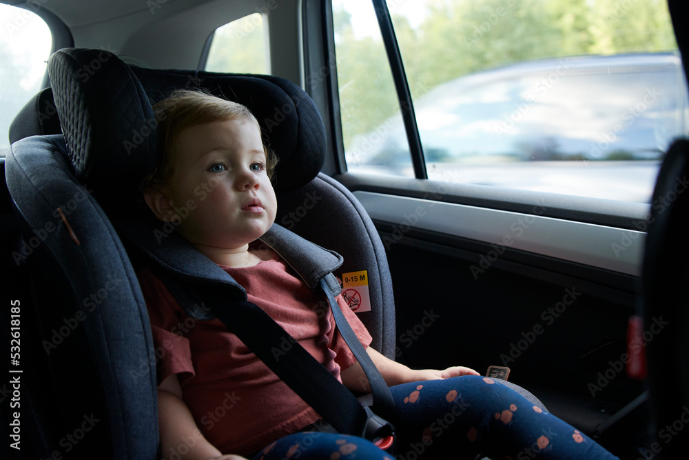 2 Year Old Girl In Car Safety Seat Looking Through The Window 2 Year Old Girl In Car Safety Seat Looking Through The Window