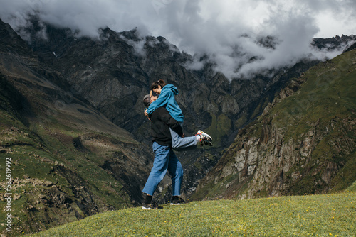 A couple of travelers in love embrace in the beautiful mountains photo