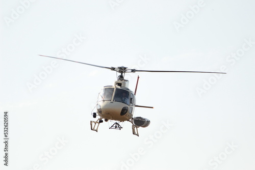 Fototapeta Naklejka Na Ścianę i Meble -  Helicoptero volando con vidrios oscuros y cielo blanco