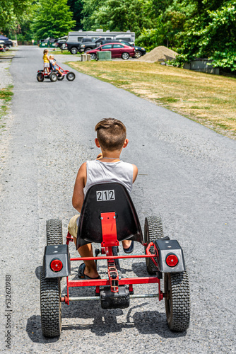 A boy on the go-cart races with sisters