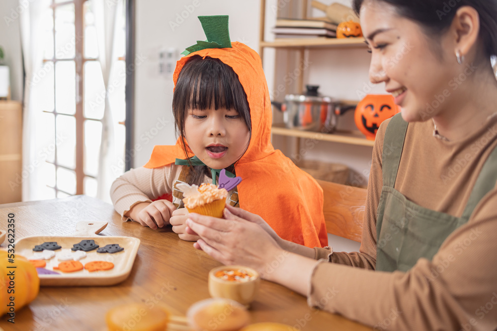 Happy halloween, Mother and her daughter having fun at home. Happy Family preparing for Halloween. Mum and child cooking festive fare in the kitchen Happy family preparing for Halloween.
