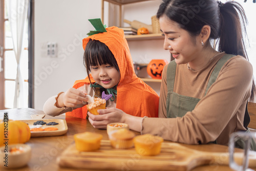 Happy halloween, Mother and her daughter having fun at home. Happy Family preparing for Halloween. Mum and child cooking festive fare in the kitchen Happy family preparing for Halloween.