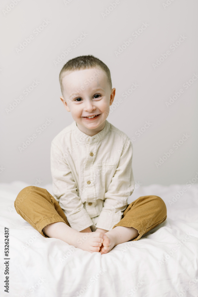 Simple portrait of a smiling toddler on a bed Simple portrait of a smiling toddler on a bed