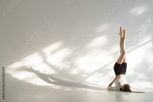 Female acrobat showing her capabilities in studio photo