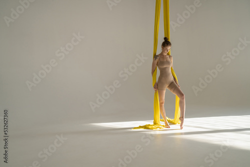Circus artist with colorful fabric ribbons indoors photo