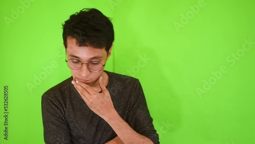 Joven hombre caucásico decepcionado o molesto en un fondo verde  photo