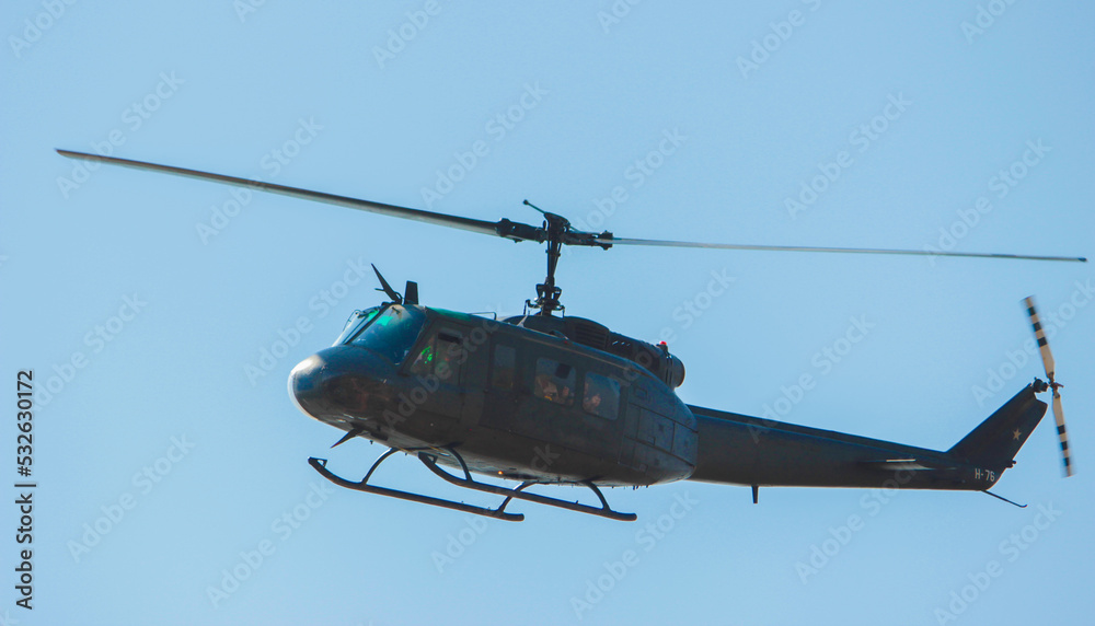 Fototapeta premium Helicóptero estilo militar de color gris oscuro o negro con fondo de cielo azul