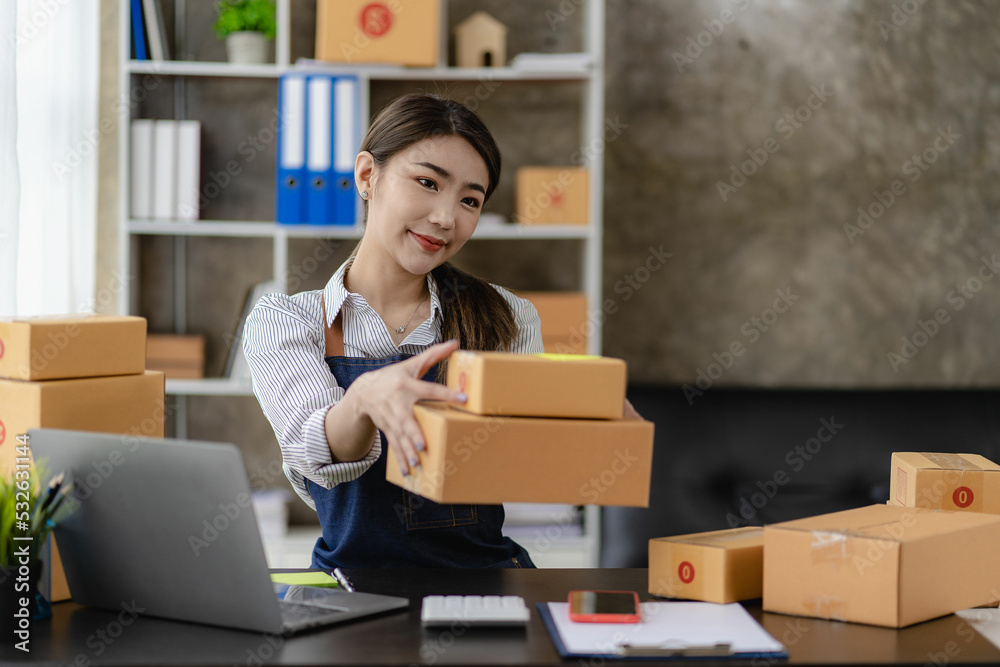 beautiful asian woman working at home selling online with yellow box and laptop on taking name orders from customers sme business concept parcel delivery beautiful asian woman working at home selling online with yellow box and laptop on taking name orders from customers sme business concept parcel delivery