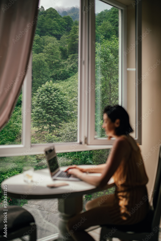 View from the window of the forest landscape with a girl with a laptop View from the window of the forest landscape with a girl with a laptop