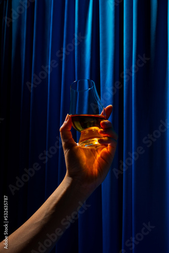 Hand rasing a glass with Whisky photo