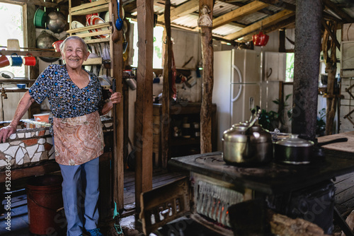 Elderly woman standing in her kitchen.  photo