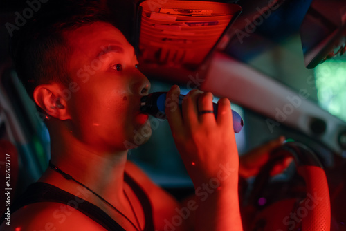 Asian man shaves with electric shaver photo