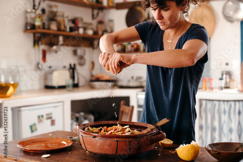 Woman cooking and seasoning with lemon photo