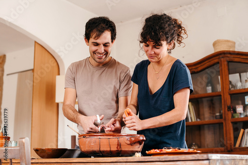 Couple cooking together in the kitchen photo