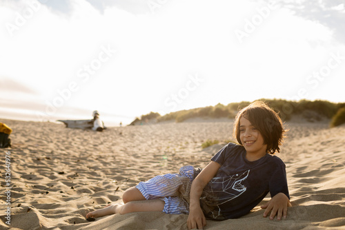 Boy lying at beach sand