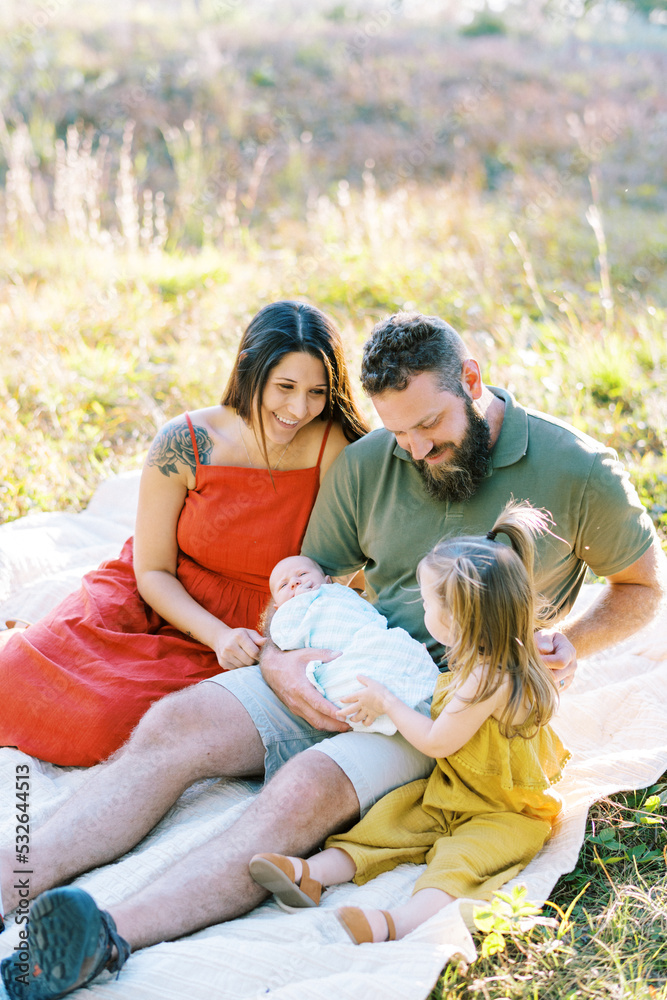 Family with toddler and newborn baby outdoors on summer night Family with toddler and newborn baby outdoors on summer night
