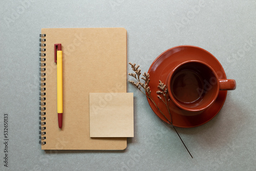 Brown notebook  pen  coffe cup on gray desk background. workspace. flat lay  top view  copy space
