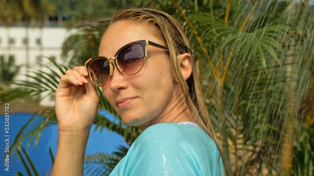 Beautiful woman taking a shower in garden near hotel. Sexy hot girl in