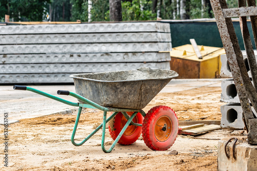 Construction metal wheelbarrow or cart close-up. Transportation of building materials at the construction site. Tool for construction work.