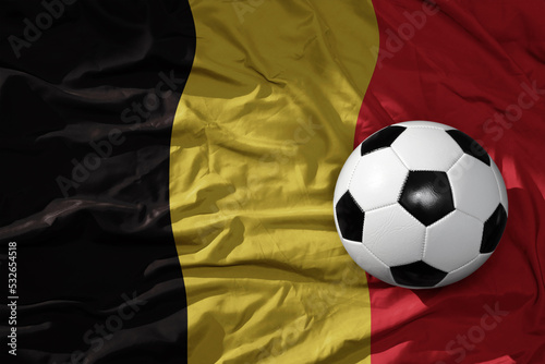 vintage football ball on the waveing national flag of belgium background. 3D illustration