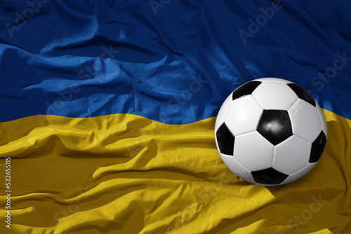 vintage football ball on the waveing national flag of ukraine background. 3D illustration