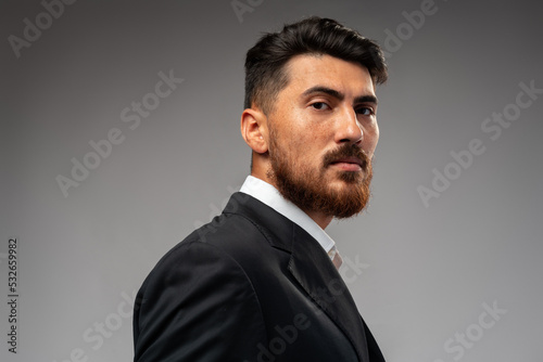 Portrait of handsome confident business on gray background