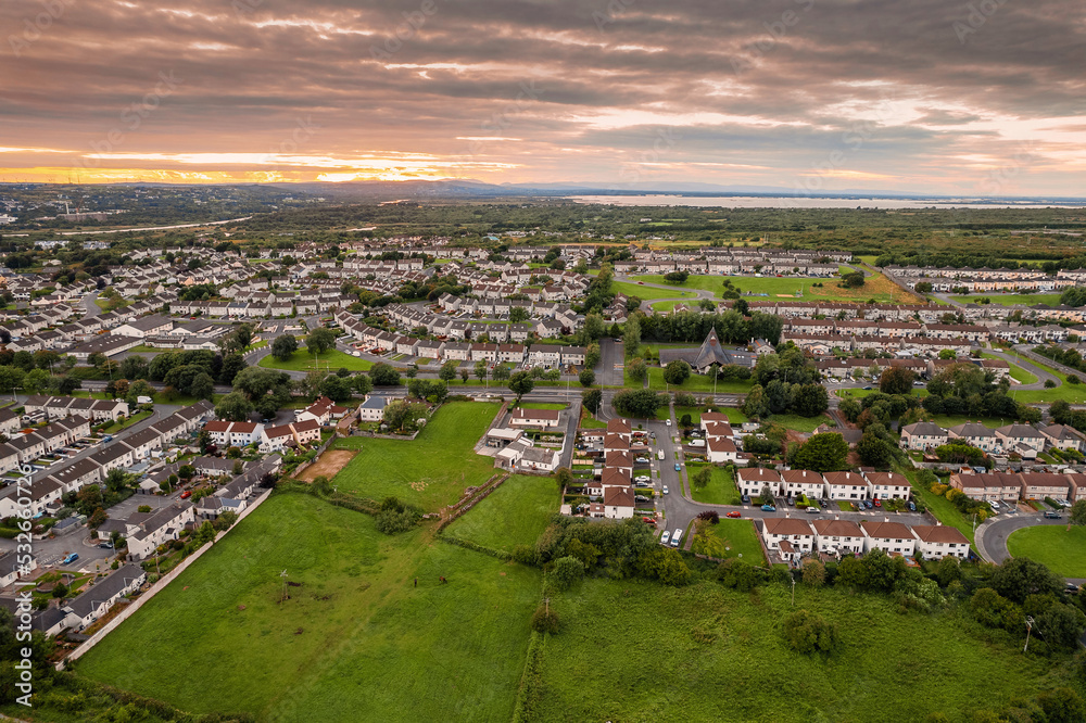 Fototapeta premium Aerial view on a city residential area with houses and park. Galway, Ireland. Blue cloudy sky. High density urban land.