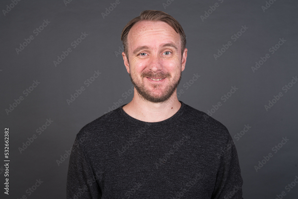 Studio portrait of blonde Caucasian man against gray background