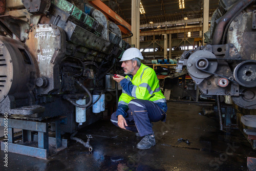 Portrait of Engineer in the process of inspecting train engines