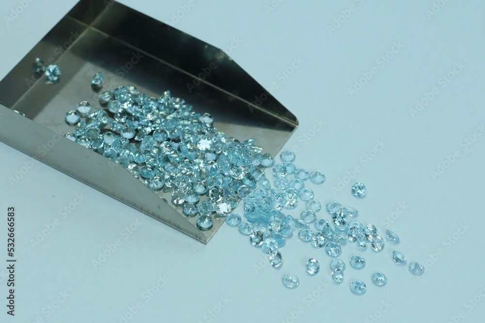 Blue aquamarine or blue topaz gemstone with light blue color on silver tray