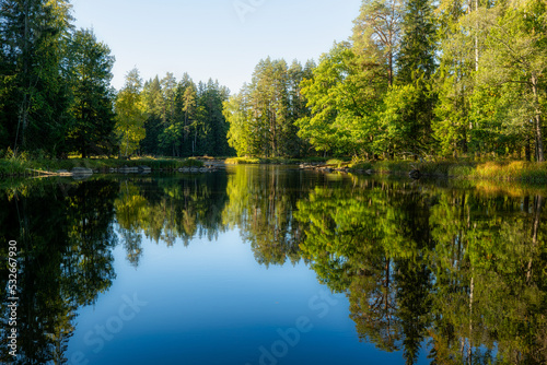 Calm lake reflection in a beautiful sunrise. Farnebofjarden national park in north of Sweden.