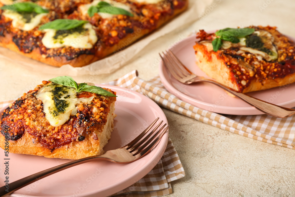 Plates of tasty Italian pie with mozzarella and pesto sauce on light table, closeup Plates of tasty Italian pie with mozzarella and pesto sauce on light table, closeup