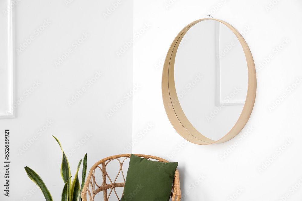 Stylish mirror hanging on light wall in room Stylish mirror hanging on light wall in room