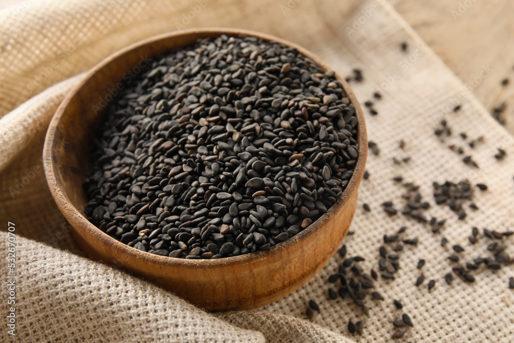 Wooden bowl of black sesame seeds on table, closeup Wooden bowl of black sesame seeds on table, closeup