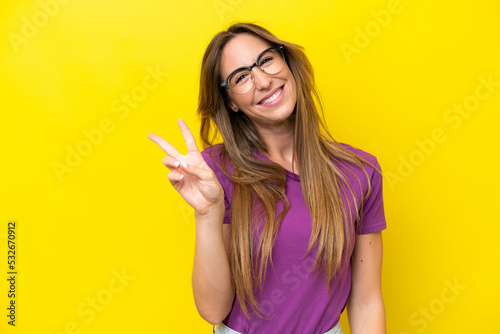 Tablou canvas Young caucasian woman isolated on yellow background With glasses and doing OK si