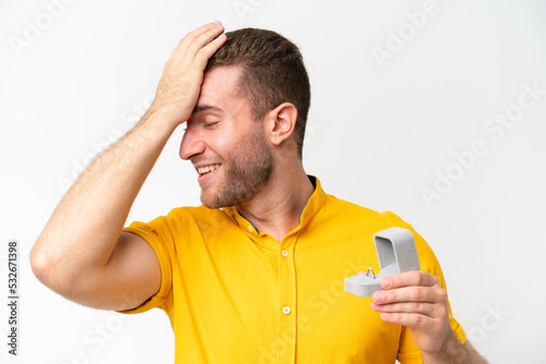 Young man holding a engagement ring isolated on white background has realized something and intending the solution