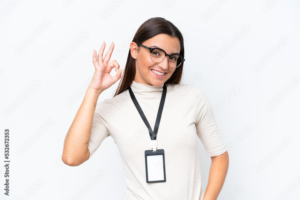 Young caucasian woman with ID card isolated on white background showing ok sign with fingers Young caucasian woman with ID card isolated on white background showing ok sign with fingers