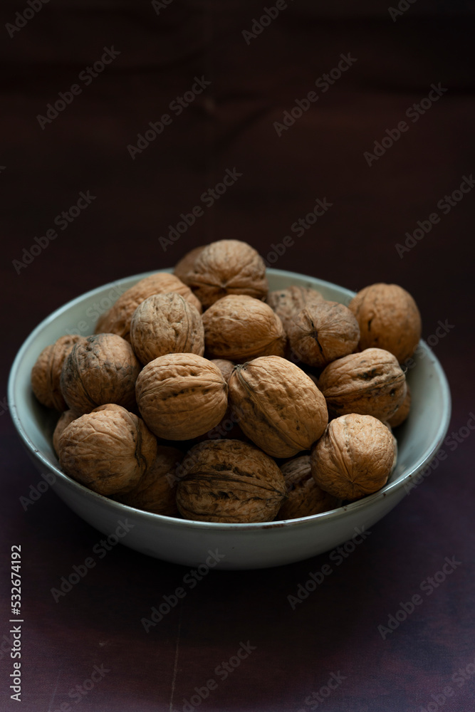 Bowl full of walnuts on black background with copy space Bowl full of walnuts on black background with copy space