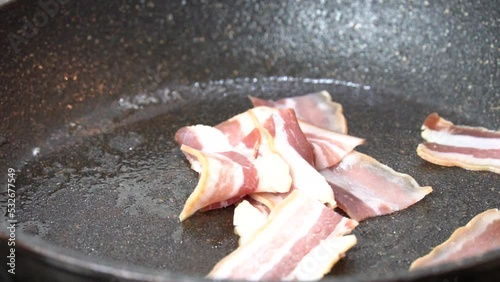 Bacon slices frying in a pan. Close up