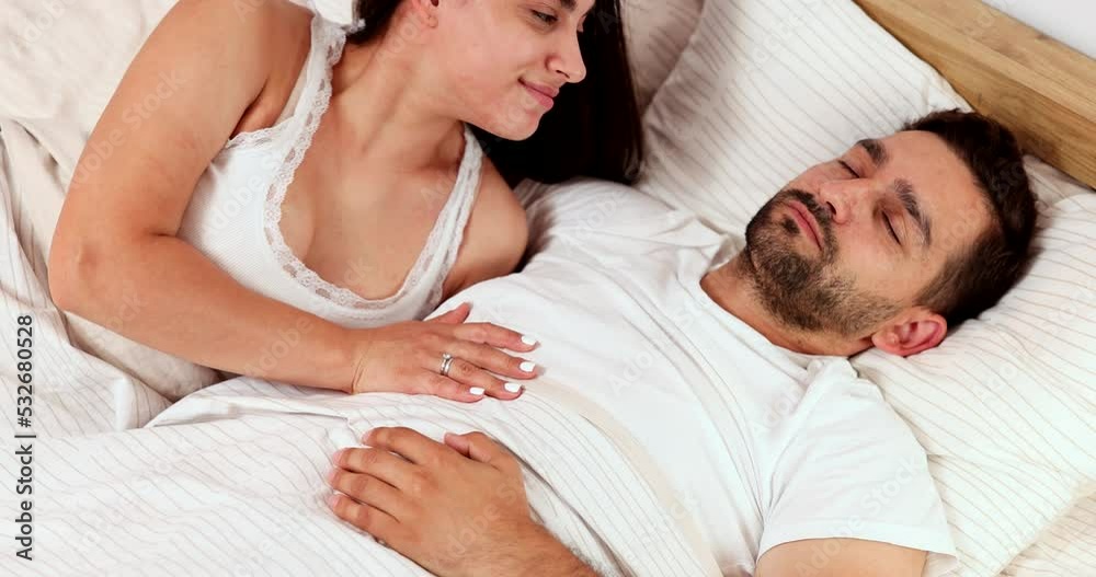 Beautiful couple in love enjoy morning in apartment. The wife wakes up the husband with a sweet kiss. Beautiful couple in love enjoy morning in apartment. The wife wakes up the husband with a sweet kiss.